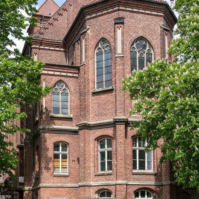 An der Seite der Kunstkirche am St. Josefshaus liegt der Eingang zu einem Künstleratelier. Viele Fenster zieren das Gebäude. (vergrößerte Bildansicht wird geöffnet)