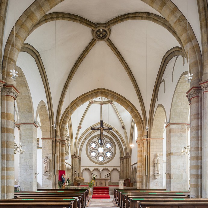 Innenraum der Kirche. Am unteren Bildrand sind die Kirchenbänke. Darüber sind der Altar und die hohen Deckengewölbe. (vergrößerte Bildansicht wird geöffnet)