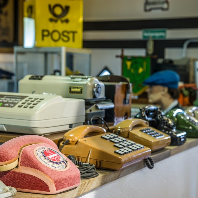 Im Innenraum des Postmuseums sind viele verschiedene Telefone und Faxgeräte. Diese Geräte wurden früher verwendet. (vergrößerte Bildansicht wird geöffnet)