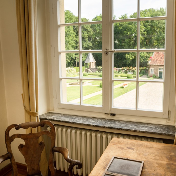 Auf dem Tisch liegt eine Medaille mit dem Porträt von Dr. Ernst Kühl. Im Hintergrund ist ein Fenster mit Blick in den Garten. (vergrößerte Bildansicht wird geöffnet)