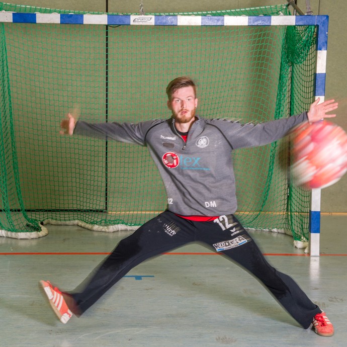 Dustin Mechelhoff ist Torwart beim Handball. Er versucht gerade einen Ball zu halten, der auf sein Tor fliegt. (vergrößerte Bildansicht wird geöffnet)
