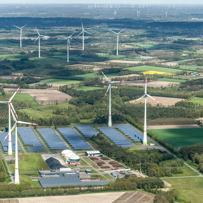 Blick von oben auf den Bioenergiepark in der Landschaft. Dazu gehören Windräder und Solaranlagen. (vergrößerte Bildansicht wird geöffnet)