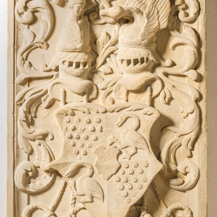Blick auf eine helle Reliefplatte. Darauf ist ein Wappen zu sehen, das die Zugehörigkeit Laers zur Grafschaft Steinfurt anzeigt. (vergrößerte Bildansicht wird geöffnet)