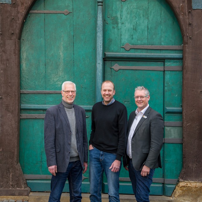 Drei Männer stehen vor einer grünen Tür. Sie sind im Stiftungsvorstand (Heinz Levedag, Gunnar Beyer, David Ostholthoff). (vergrößerte Bildansicht wird geöffnet)