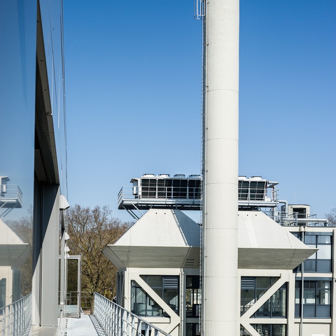 Vor blauem Himmel steht das Technik-Gebäude auf dem Campus. In diesem Kraftwerk werden Strom und Wärme erzeugt. (vergrößerte Bildansicht wird geöffnet)