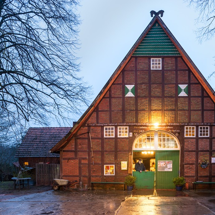 Das Gebäude des Traktorenmuseums ist ein Fachwerkhaus mit spitzem Dach und einem grünen Eingangstor. (vergrößerte Bildansicht wird geöffnet)
