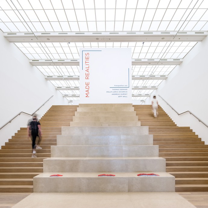 Blick in einen sehr hellen Raum. Eine große Treppe mit breiten Stufen führt zu einer Sonderausstellung des Museums. (vergrößerte Bildansicht wird geöffnet)