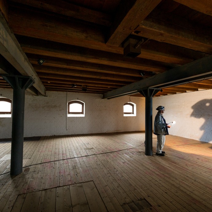Blick in einen großen Raum. An eine weiße Wand wirft Christian Hesse einen großen Schatten, der wie ein Hase aussieht. (vergrößerte Bildansicht wird geöffnet)